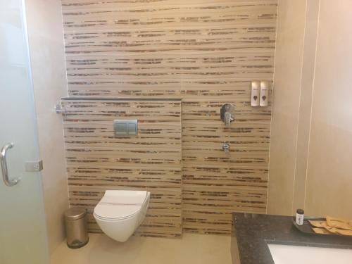 baño con aseo y pared de madera en HOTEL KADAMB TREE en Jabalpur