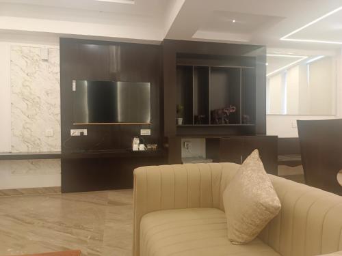 a living room with a couch and a television at HOTEL KADAMB TREE in Jabalpur