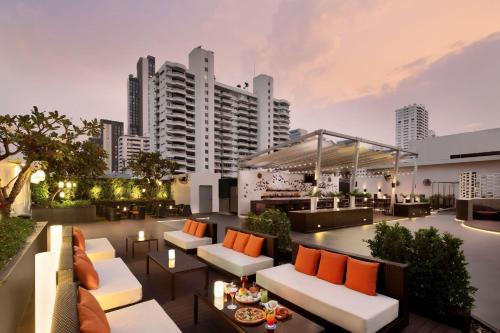 a rooftop patio with white couches and orange pillows at Four Points by Sheraton Bangkok, Sukhumvit 15 in Bangkok