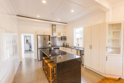 a kitchen with white cabinets and a black counter top at Feels like your home ! in Auckland