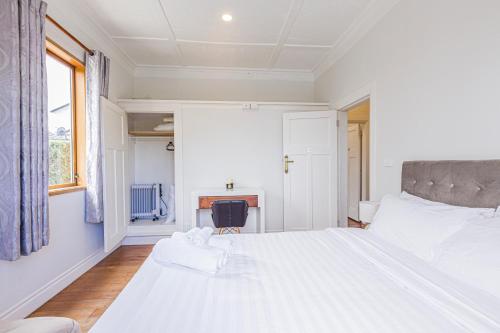 a bedroom with a large white bed and a desk at Feels like your home ! in Auckland