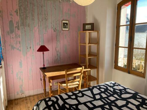 Schlafzimmer mit einem Schreibtisch, einem Tisch und einem Bett in der Unterkunft Maison Locmaria, 4 pièces, 6 personnes - FR-1-418-245 in Locmaria