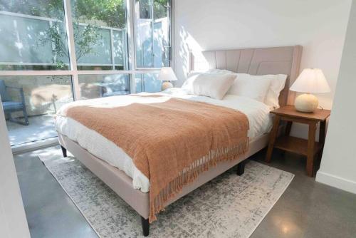 a bedroom with a bed and a large window at Fiera WeHo residence in Los Angeles