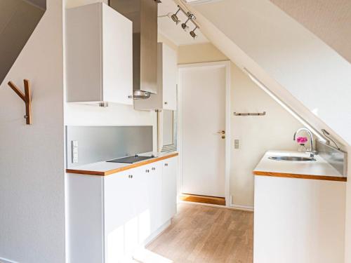 a kitchen with white cabinets and a sink at 3 person holiday home in Svaneke in Svaneke