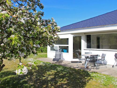 ein Haus mit einer Terrasse mit einem Tisch und Stühlen in der Unterkunft 4 person holiday home in Svaneke in Svaneke