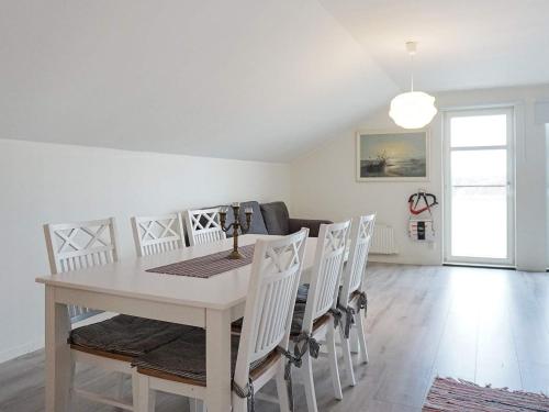 un comedor blanco con una mesa y sillas blancas en 6 person holiday home in KUNGSHAMN en Kungshamn