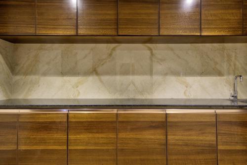 a kitchen with wooden cabinets and a sink at Lance 21 - Ashok Nagar in Chennai