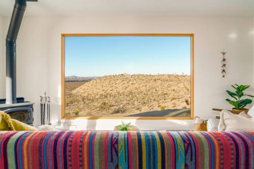 a large window in a room with a colorful couch at Pipe's Perch in Yucca Valley