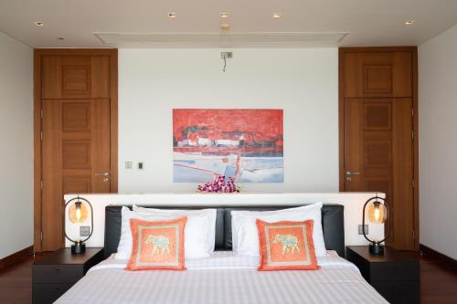 een slaapkamer met een bed met oranje en witte kussens bij Malaiwana Villa N in Nai Thon Beach