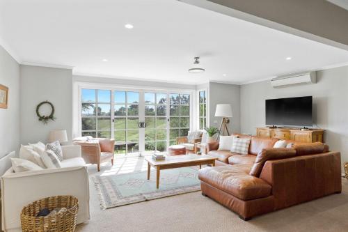 Una sala de estar con un sofá y un televisor. en Haven Hills, en Korumburra