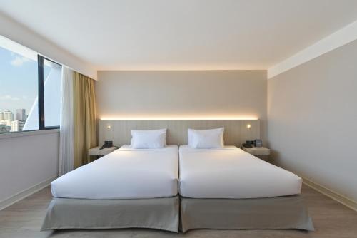 Postel nebo postele na pokoji v ubytování Twin Towers Hotel
