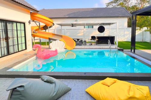 una piscina con un tobogán en una casa en BreezyS Pool Villa, en Nong Prue