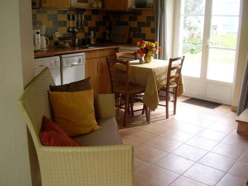 a kitchen with a couch and a table with chairs at Maison Locmaria, 2 pièces, 2 personnes - FR-1-418-252 in Locmaria