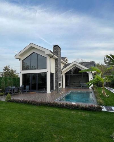 uma casa com uma piscina em frente em Villa La Altragracia em Constanza