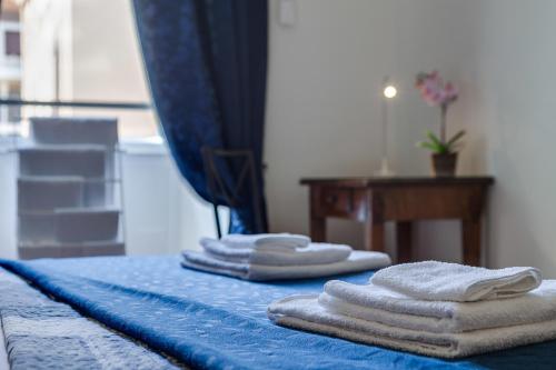 un grupo de toallas sentadas encima de una cama en Otium Maecenatis Apartments, en Roma