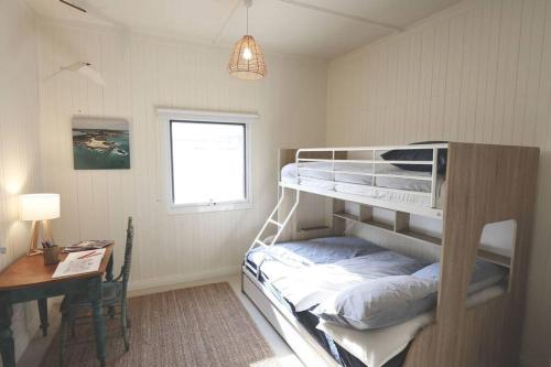 a bedroom with a bunk bed and a desk with a desk at Maisie's Robe - Dog Friendly - Wi-Fi in Robe