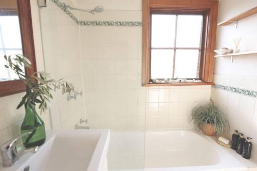a white bath tub in a bathroom with a window at Maisie's Robe - Dog Friendly - Wi-Fi in Robe
