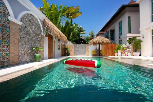 a pool with a inflatable raft in the water at Nagawari Art Maldives BBQ Pattaya Villa in Na Jomtien