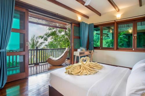 a bedroom with a bed and a balcony with a hammock at Rawa Island Resort in Mersing