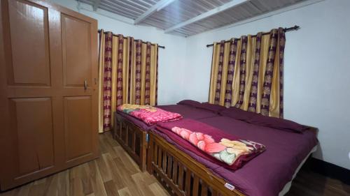 a bed in a room with curtains and a door at Paradise Cottage Vattavada, Munnar in Vattavada