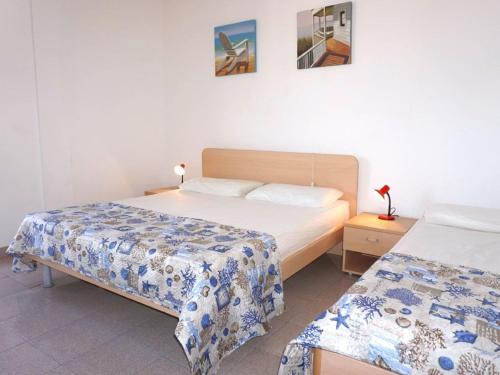 a bedroom with two beds and a night stand with a bed sidx sidx at Cosy apartment with balcony in Porto Santa Margherita di Caorle