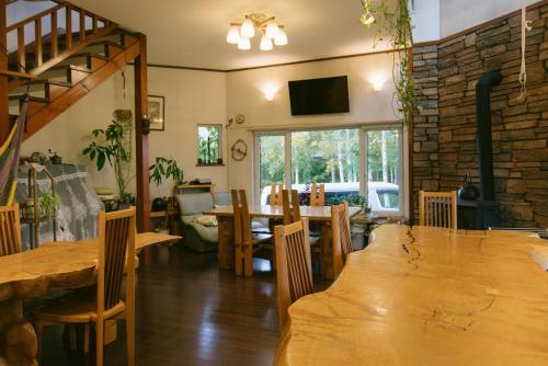 a dining room with a wooden table and chairs at Pension Ashitaya in Furano