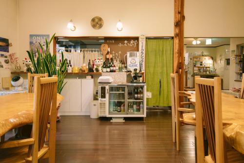 a room with a table and chairs and a store at Pension Ashitaya in Furano