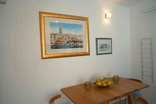 a dining room table with a bowl of fruit on it at Apartments Apartmani Oh La La - terrace in Supetar