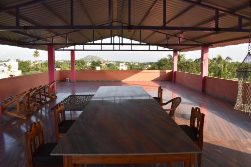 a wooden table and chairs on a roof at Rainbow Guest House in Tiruvannāmalai