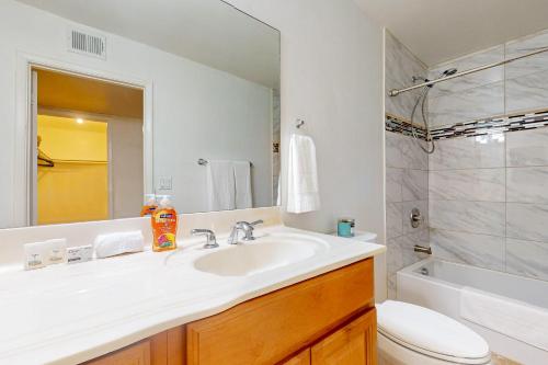 een badkamer met een wastafel, een toilet en een spiegel bij Paradise in Phoenix in Phoenix