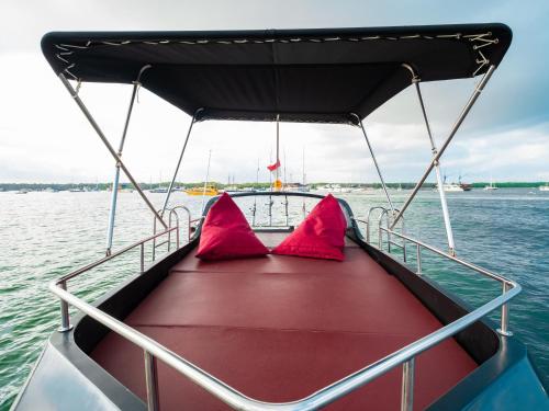 a boat with two red pillows on the water at Queen Ruizi Private Yacht Charter in Pesanggaran