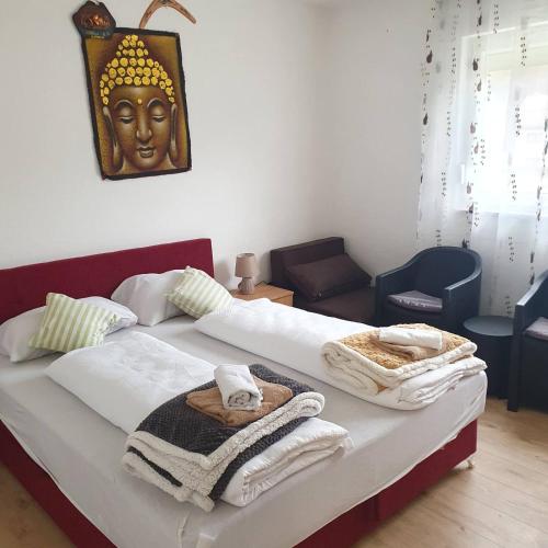 a bedroom with two beds with towels and a mask on the wall at HOLIDAY HOUSE MARIC 