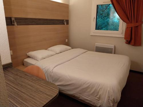 1 dormitorio con 2 camas y ventana en beaujour & bonsoir Brasserie-Hotel, en Villy-le-Pelloux