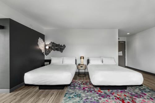 two beds in a room with a rug at Aloft Columbus Easton in Columbus