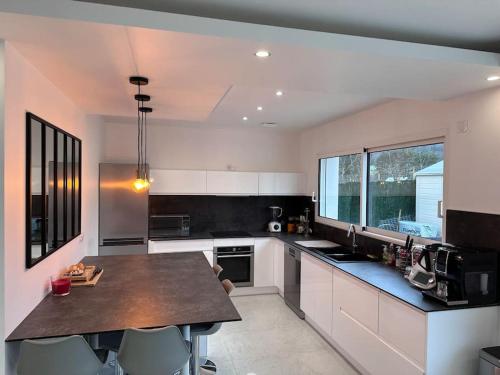 a kitchen with a large island in the middle at Magnifique Villa avec piscine in Corcelles-les-Monts