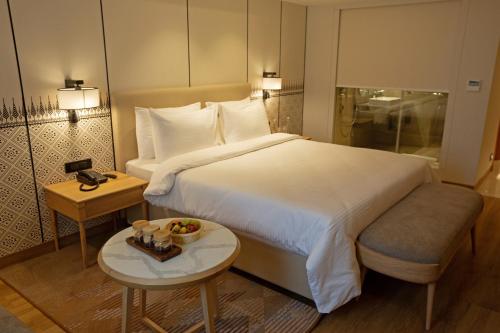 a hotel room with a bed and a bowl of fruit on a table at ARISTA BY AMBITION in Guwahati