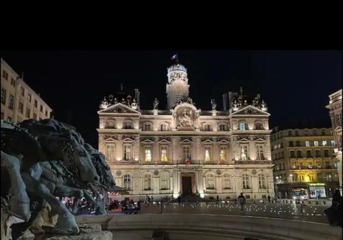 a large building with a clock tower at night at Chic & Elégance Lyon Centre in Lyon