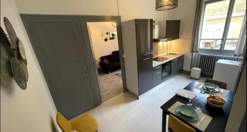 Cette chambre comprend une cuisine avec une table et une porte. dans l'établissement Chic & Elégance Lyon Centre, à Lyon
