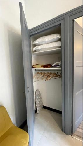 un placard avec une porte grise et une chaise jaune dans l'établissement Chic & Elégance Lyon Centre, à Lyon