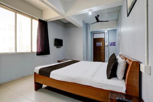 a bedroom with a bed and a television in it at OYO Hotel Sama Residency in Vadodara