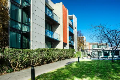 un bâtiment avec une cour d'herbe devant lui dans l'établissement Phillip Island Apartments, à Cowes