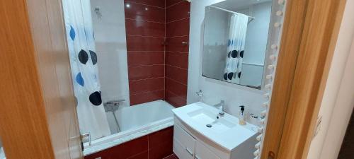 uma casa de banho com um lavatório branco e um chuveiro em Oméga em El Aouina