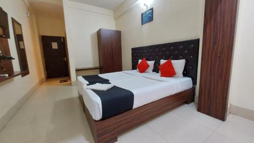 a bedroom with a large bed with red pillows at Hotel Tripletree Bhubaneswar in Bhubaneshwar