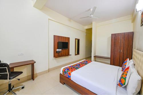 a bedroom with a bed and a desk and a computer at Hotel Tripletree Bhubaneswar in Bhubaneshwar