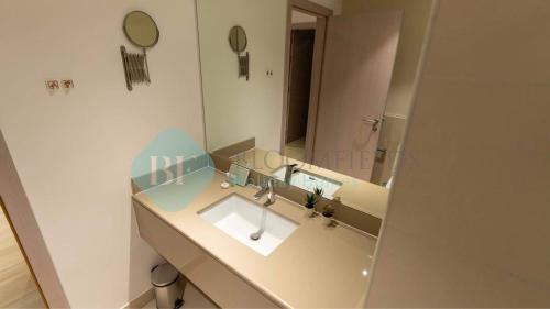 a bathroom with a sink and a large mirror at Stylish 1bedroom In Water Edge in Abu Dhabi