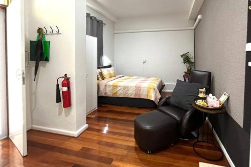 a bedroom with a bed and a chair in a room at Comfortable Studio+free parking for small car in Sydney