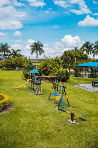 a park with a playground with slides and swings at Finca Hotel Palmas Del Edén in Armenia