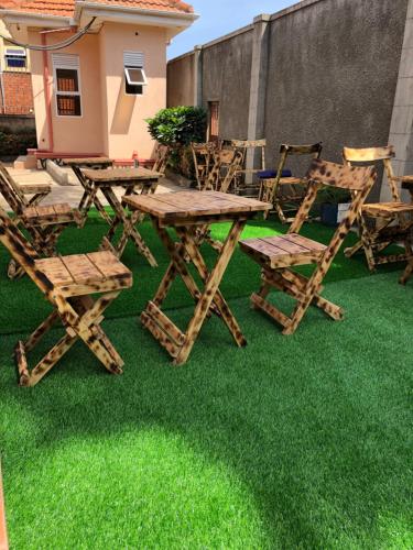坎帕拉的住宿－HIS&HERS MOTEL by MATHIAS，草地上的野餐桌和椅子