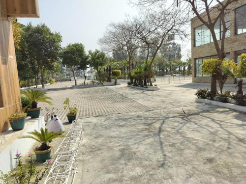 un patio con macetas y un edificio en Kingston banquet and event center en Kurukshetra