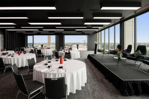 a conference room with tables and chairs and windows at Aloft Perth in Perth